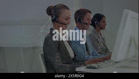 Caucasian group wearing headsets, working on computers Stock Photo