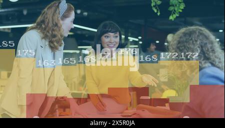 Image of statistical data processing against group of diverse colleagues discussing at office Stock Photo