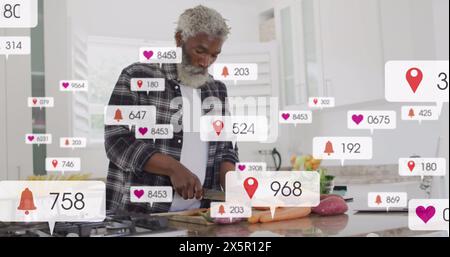 Image of multiple notification bars, senior african american man cutting vegetables in kitchen Stock Photo