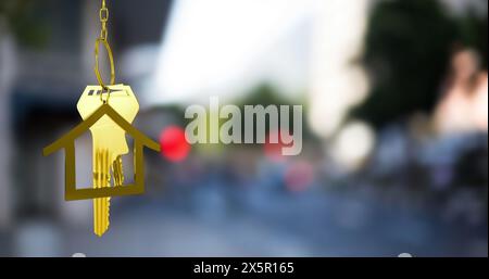 Image of gold house key and fob over out of focus cityscape Stock Photo