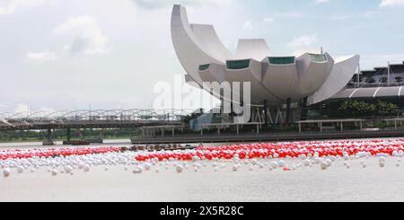 red and white balloons over the river with a background of modern buildings Stock Photo
