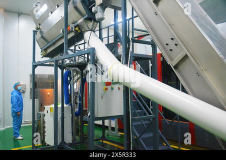 ANQING, CHINA - MAY 11, 2024 - A worker is working on a bottled water production line at a workshop of a beverage company in Anqing city, East China's Stock Photo