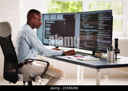 African American Coder Using Computer At Desk. Web Developer Stock Photo
