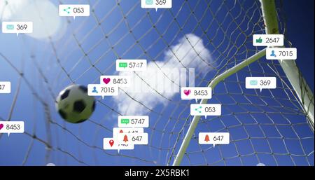 Image of numbers, icons in notification bars, close up of soccer ball hitting net against sky Stock Photo