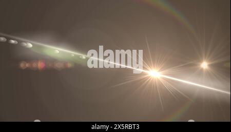 Digital image of spot of light and lens flare against copy space on grey background Stock Photo