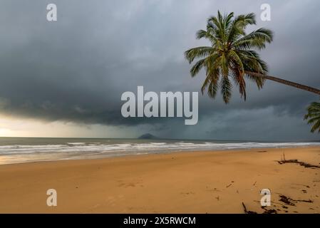 A tropical rain storm and heavy low grey clouds approaching Mission Beach from the south east in Far North Queensland, Australia Stock Photo