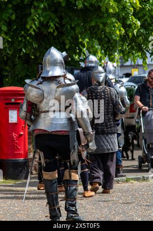 Medieval re-enactment group the Suffolk Knights having attended an 'individual' wedding at the Unitarian church in Framlingham walk through the town Stock Photo