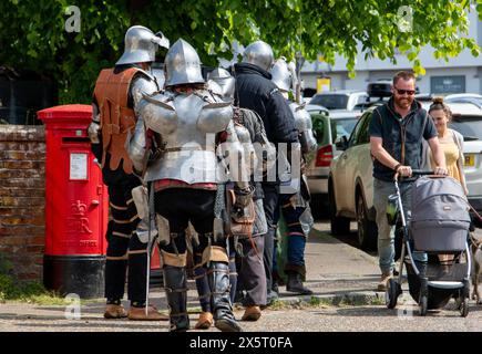 Medieval re-enactment group the Suffolk Knights having attended an 'individual' wedding at the Unitarian church in Framlingham walk through the town Stock Photo