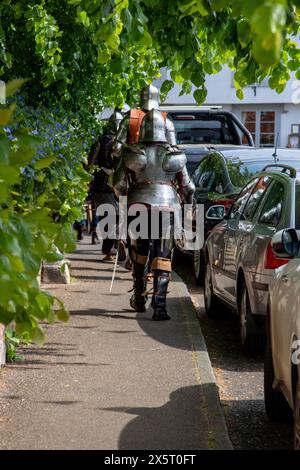 Medieval re-enactment group the Suffolk Knights having attended an 'individual' wedding at the Unitarian church in Framlingham walk through the town Stock Photo