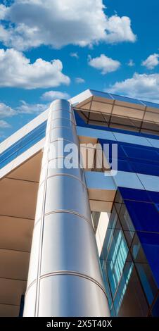 office building, generic, column partial view, blue windows and bright sky with cumulus clouds Stock Photo