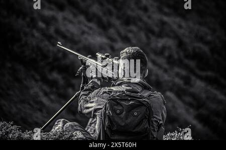 Hunting period. Hunter is aiming. The man is on the hunt. Hunter with shotgun gun on hunt. Deer hunt. Hunter in camouflage clothes ready to hunt with Stock Photo