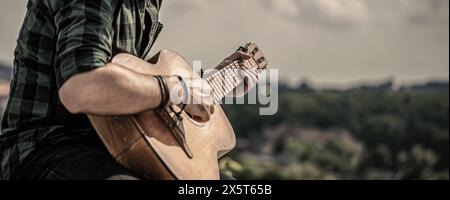 Music lifestyle man playing guitar nature concept. Hands of man musician playing guitar. Music concept Stock Photo