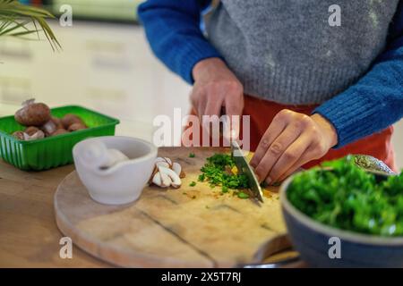 Woman chopping parsley at home Stock Photo