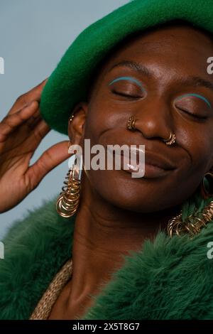 Smiling young woman wearing jewelry and beret Stock Photo