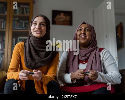 Women playing video game at home Stock Photo