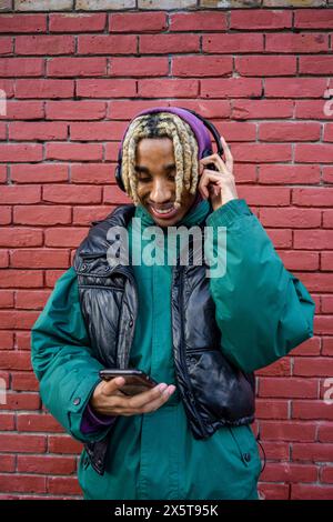 Smiling young man listening to music Stock Photo