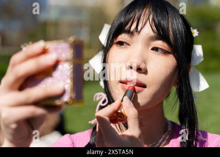 Young woman applying lip product Stock Photo
