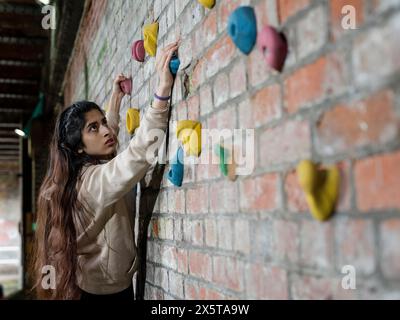 Young woman climbing on wall Stock Photo