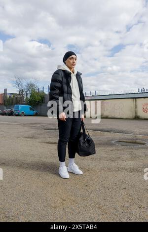 Young woman in sports clothing standing outdoors Stock Photo