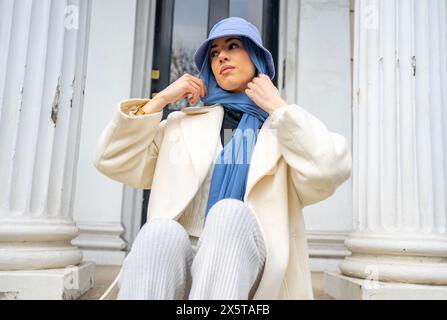 Young woman wearing hijab and bucket hat Stock Photo