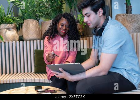 Colleagues using digital tablet during meeting in office Stock Photo