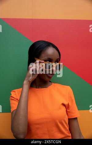 Smiling young woman in orange sunglasses Stock Photo