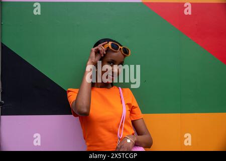 Portrait of smiling young woman in orange sunglasses Stock Photo