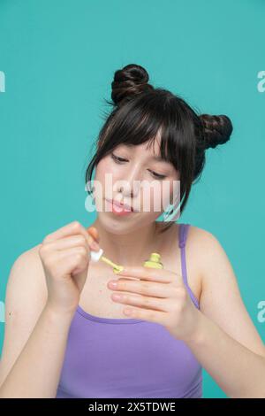 Studio portrait of girl painting nails Stock Photo