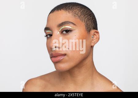 Studio portrait of woman with golden foil make-up Stock Photo