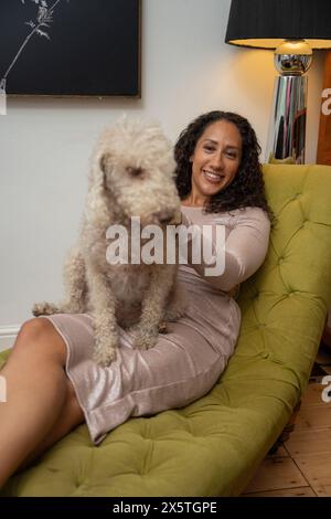 Woman sitting with bedlington terrier on her lap Stock Photo