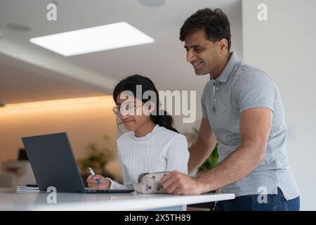 Father helping daughter doing homework Stock Photo