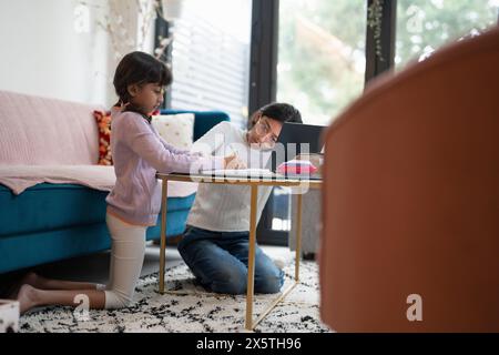 Two sisters doing homework in living room Stock Photo