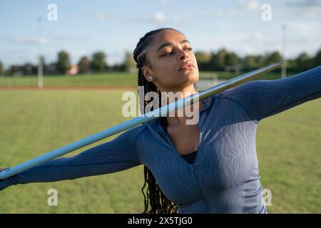 Portrait of female athlete throwing javelin Stock Photo