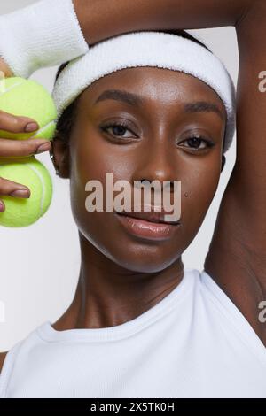 Studio portrait of athletic woman with tennis balls Stock Photo