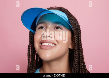 Studio portrait of smiling girl wearing sun visor Stock Photo