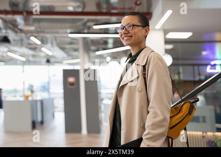 Non binary office worker walking in hallway Stock Photo