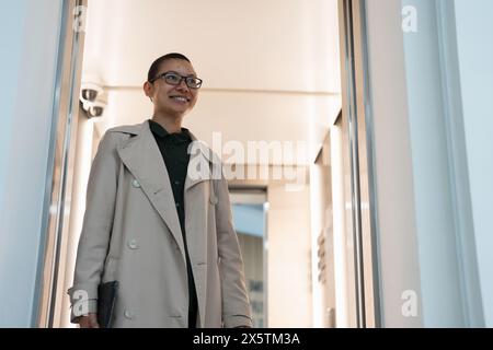 Non binary office worker walking in hallway Stock Photo