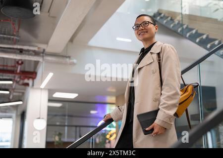 Non binary office worker walking on steps Stock Photo