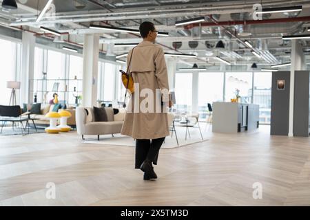 Non binary office worker walking in hallway Stock Photo