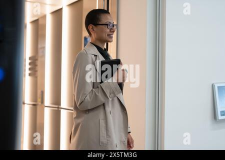 Non binary office worker walking in hallway Stock Photo