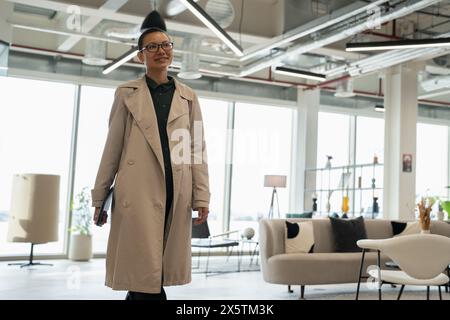 Non binary office worker walking in hallway Stock Photo