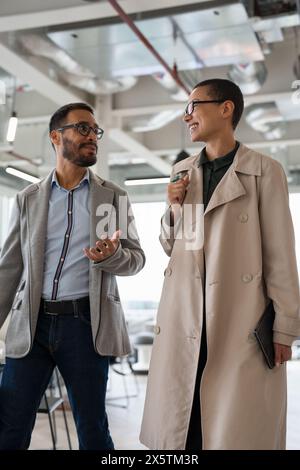 Office workers walking together in hallway Stock Photo
