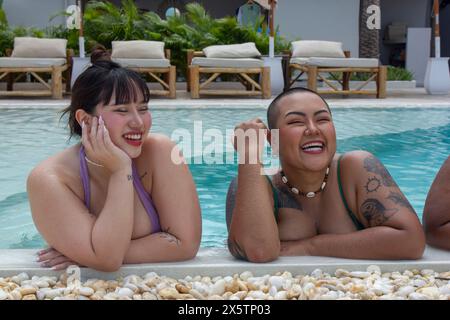 Two cheerful women relaxing on poolside Stock Photo