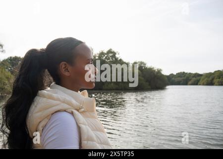 Portrait of young woman standing on lakeshore Stock Photo