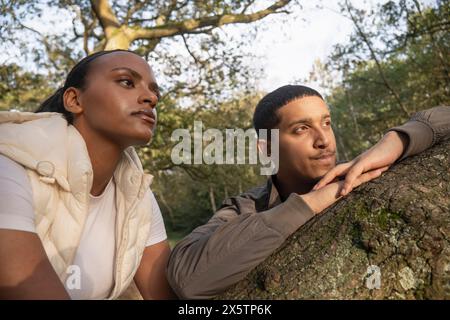 Portrait of couple leaning on tree branch Stock Photo