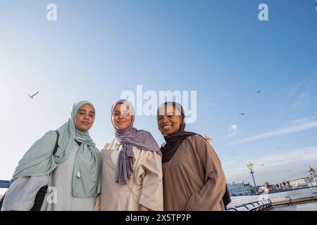 Portrait of three Muslim women standing on pier Stock Photo