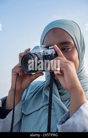 Portrait of Muslim woman photographing with analog camera Stock Photo