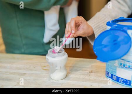 Mother preparing baby formula at home Stock Photo