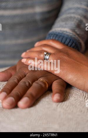 Woman holds hand on top of mans hand, close up Stock Photo