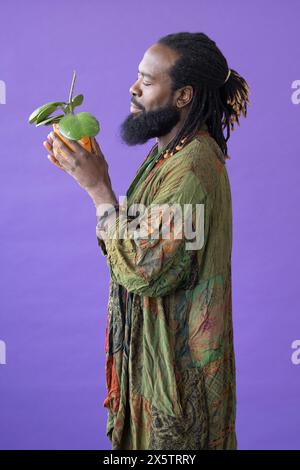Profile of man holding potted plant and smiling Stock Photo - Alamy